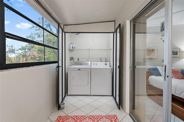 laundry room with independent washer and dryer, a textured ceiling, and light tile patterned floors