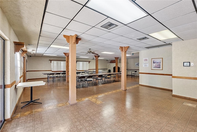 basement featuring a paneled ceiling and ceiling fan