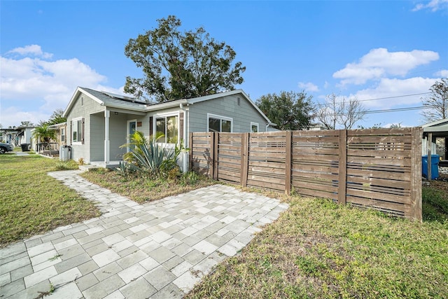 view of side of property with solar panels, a yard, and a patio