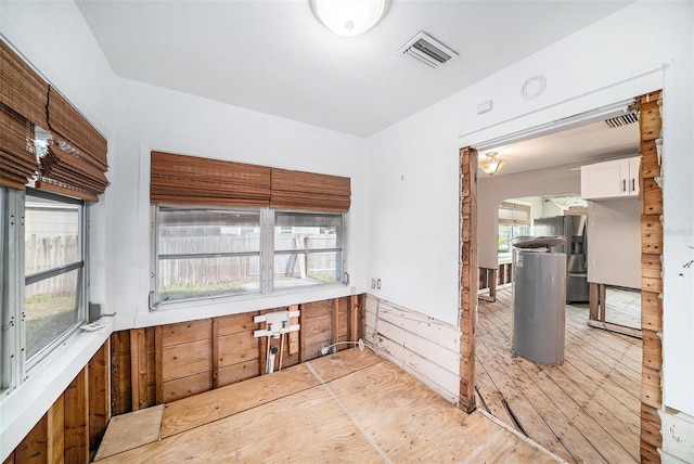 kitchen featuring stainless steel fridge with ice dispenser and white cabinetry