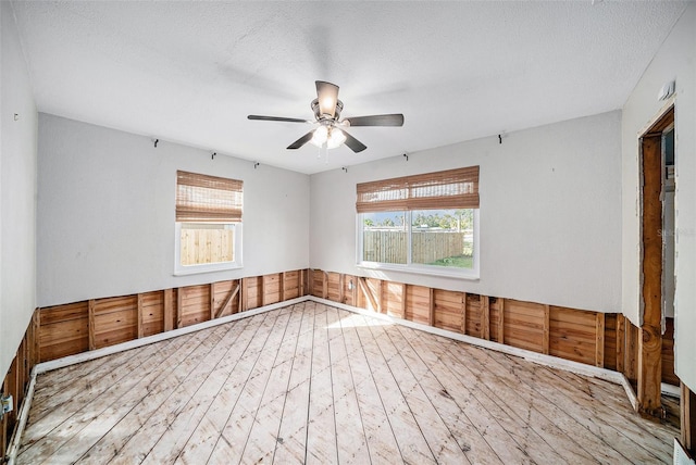 empty room featuring ceiling fan, a textured ceiling, and hardwood / wood-style flooring