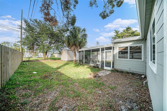 view of yard with a sunroom and a storage unit