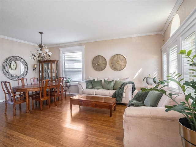 living room featuring crown molding, wood-type flooring, and a notable chandelier