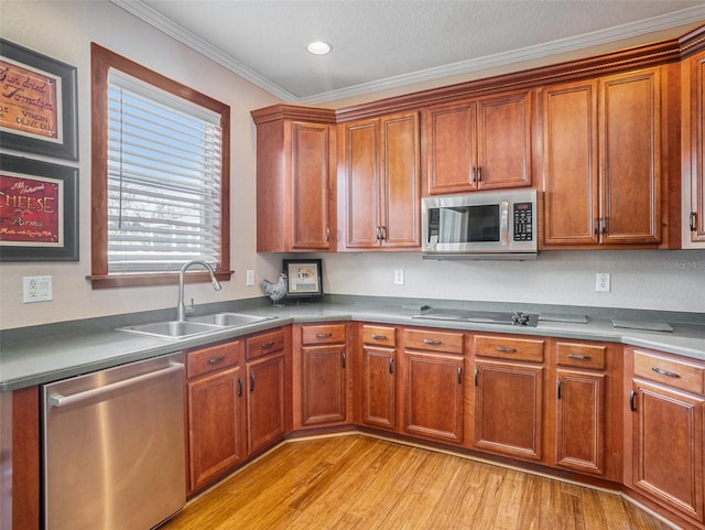 kitchen with appliances with stainless steel finishes, light hardwood / wood-style flooring, ornamental molding, and sink