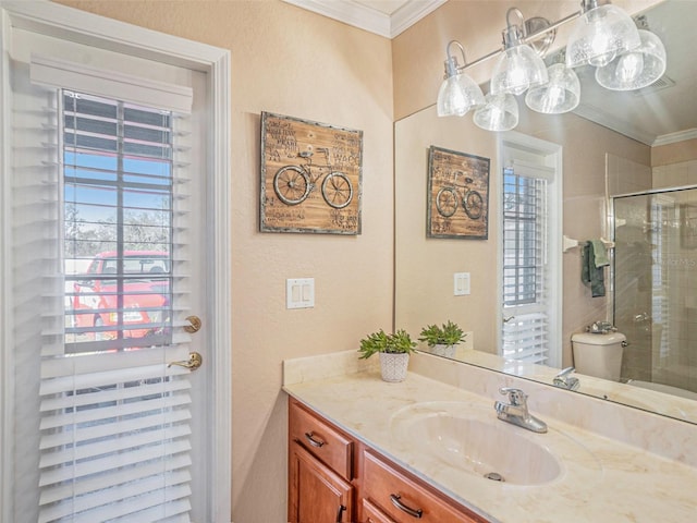 bathroom with toilet, vanity, a shower with shower door, and ornamental molding