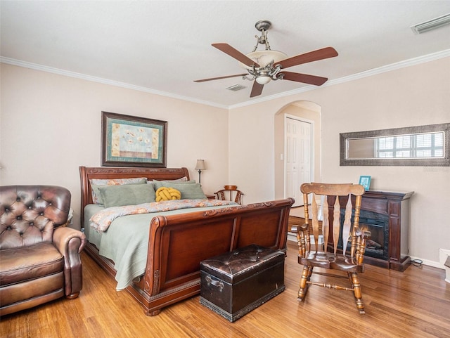 bedroom featuring a closet, crown molding, ceiling fan, and hardwood / wood-style flooring