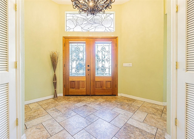 entryway featuring an inviting chandelier and french doors