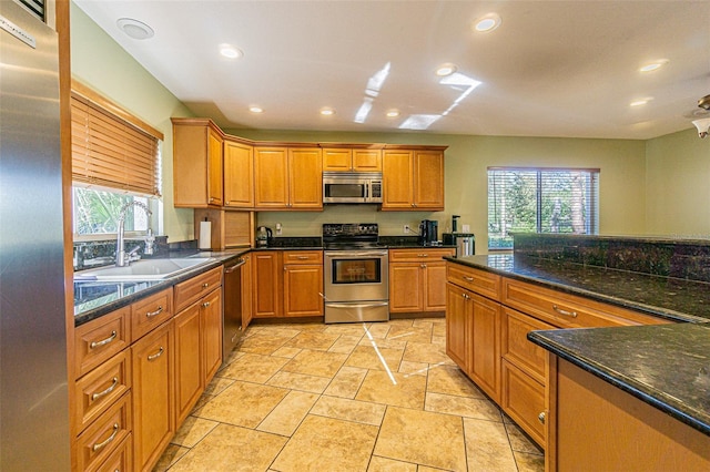 kitchen featuring sink, stainless steel appliances, and dark stone counters