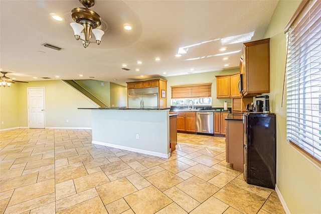 kitchen with ceiling fan, sink, stainless steel appliances, and a center island