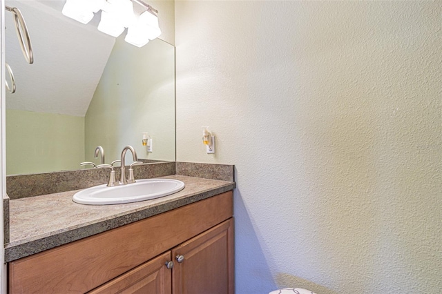 bathroom featuring vaulted ceiling and vanity