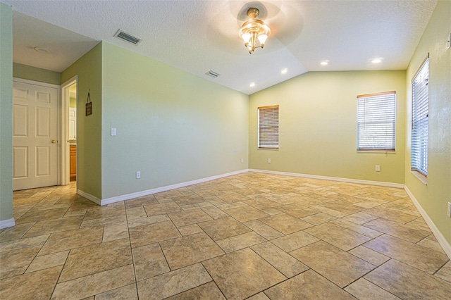 unfurnished room with lofted ceiling, ceiling fan, and a textured ceiling