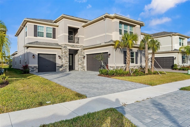 view of front of property featuring a balcony, a front lawn, and a garage