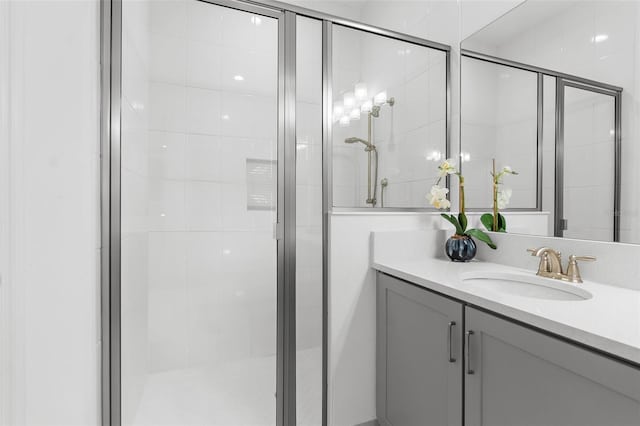 bathroom with a shower with door and vanity