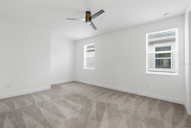 carpeted spare room with ceiling fan