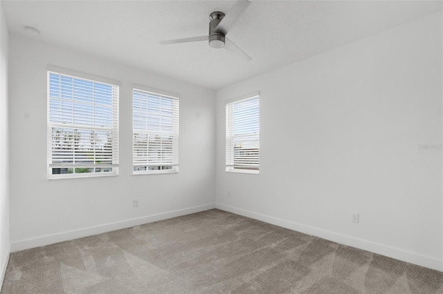 spare room featuring light carpet and ceiling fan