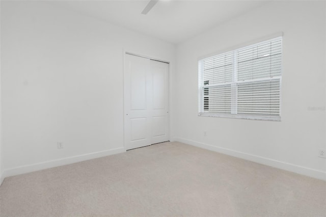 carpeted spare room with ceiling fan