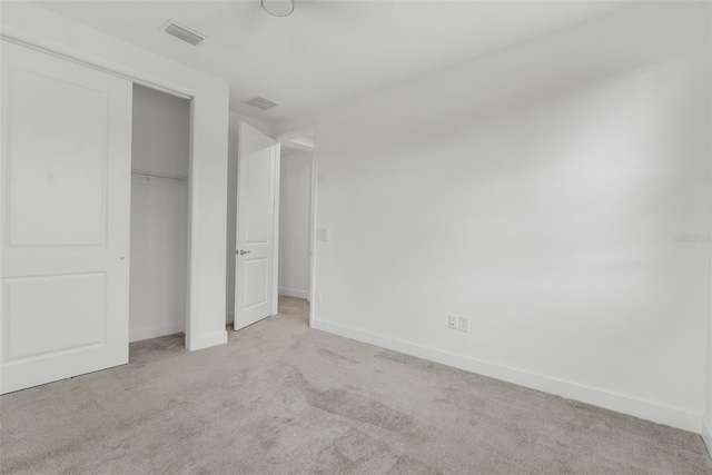 unfurnished bedroom featuring a closet and light carpet