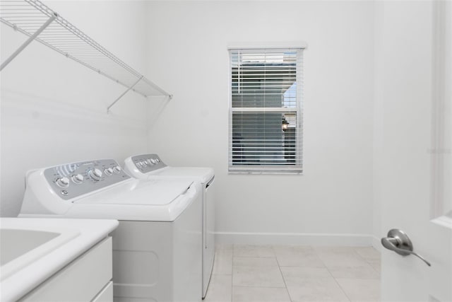 laundry room with washer and dryer and light tile patterned floors