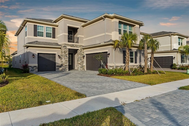 view of front of home with a balcony, a yard, and a garage