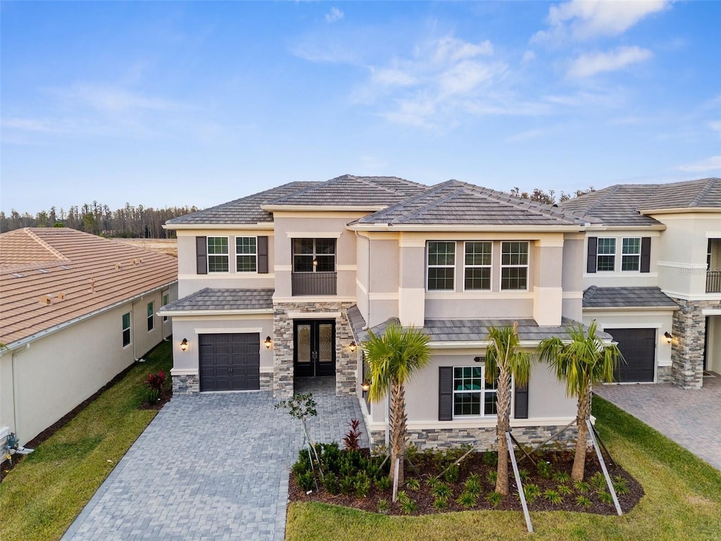 32317 Rosewood Meadow Ln, Wesley Chapel, FL 33543 - view of front of house with decorative driveway, a garage, stone siding, and stucco siding