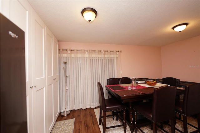 dining area with dark wood-type flooring and a textured ceiling