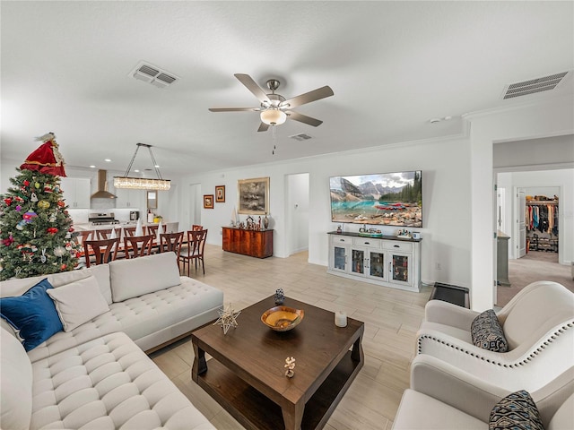 living room with ceiling fan and ornamental molding