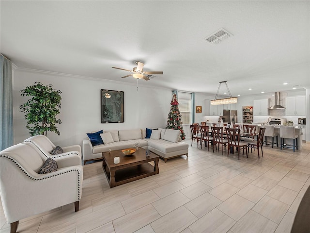 living room with ceiling fan and ornamental molding