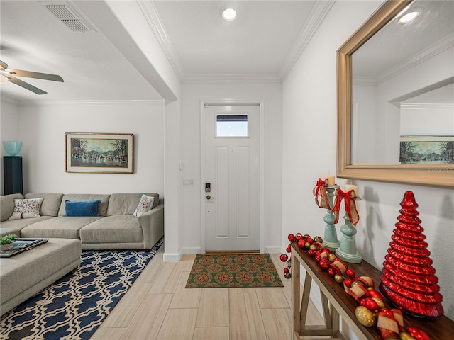 foyer featuring ceiling fan and ornamental molding