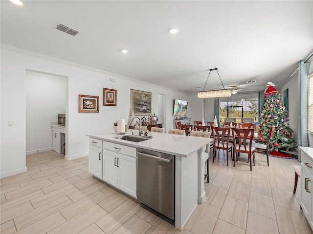 kitchen with white cabinets, ceiling fan, sink, dishwasher, and an island with sink