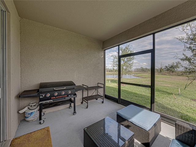 sunroom featuring a water view