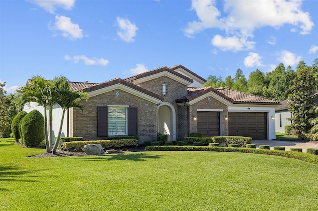 mediterranean / spanish home featuring a garage and a front yard