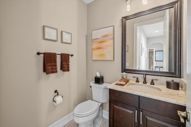 bathroom featuring tile patterned flooring, vanity, and toilet