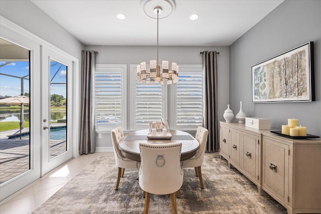 tiled dining space featuring french doors and a notable chandelier