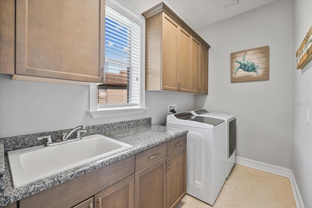 laundry room featuring cabinets, light tile patterned floors, washer and dryer, and sink