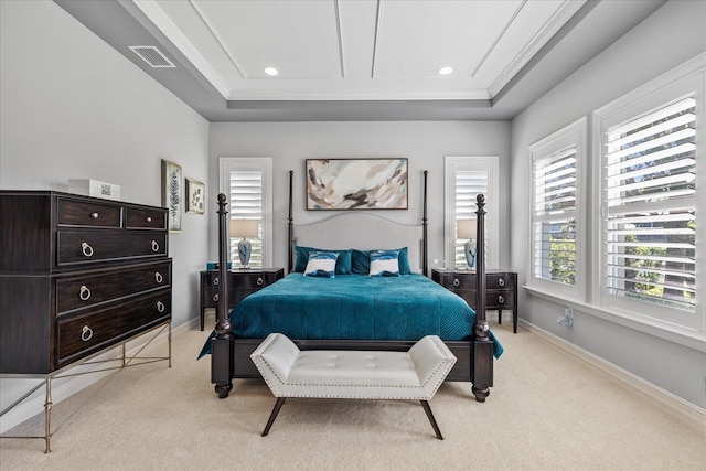 bedroom featuring a raised ceiling, light colored carpet, and ornamental molding