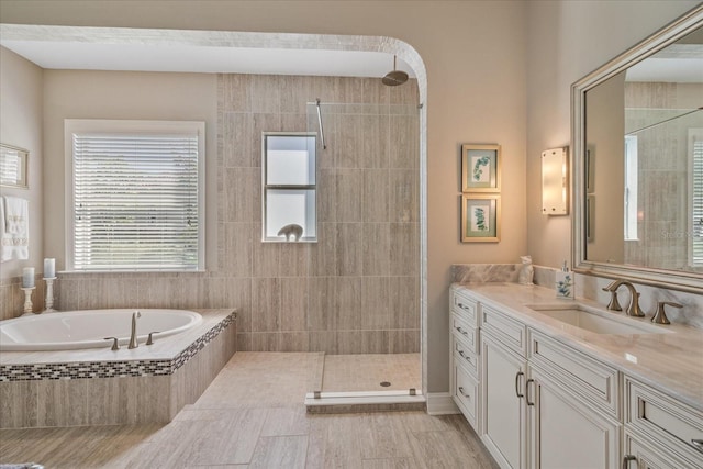 bathroom featuring tile patterned floors, vanity, and shower with separate bathtub