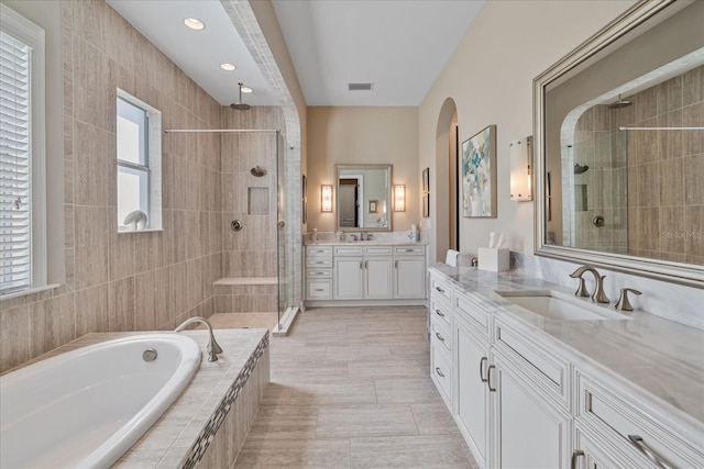 bathroom featuring tile patterned floors, vanity, and plus walk in shower