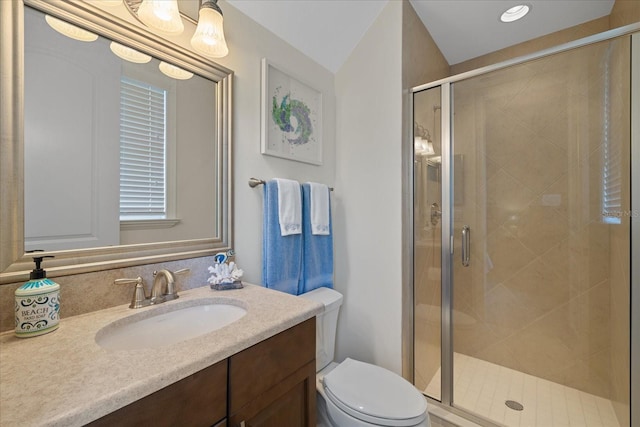 bathroom featuring toilet, vanity, lofted ceiling, and walk in shower