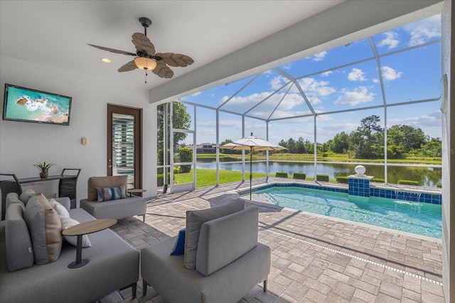 view of swimming pool with a water view, glass enclosure, ceiling fan, and a patio area