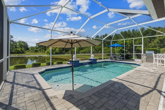 view of pool with a lanai, exterior kitchen, a water view, grilling area, and a patio