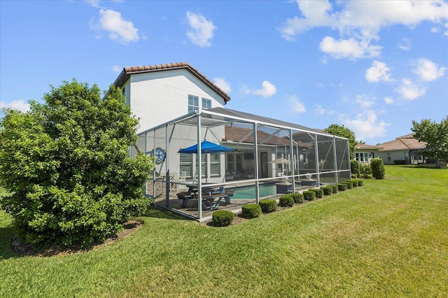 rear view of property with a lanai, a yard, and a patio