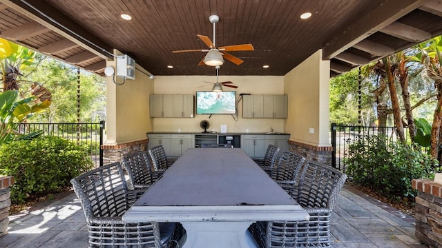 view of patio / terrace featuring a bar, an outdoor kitchen, and ceiling fan