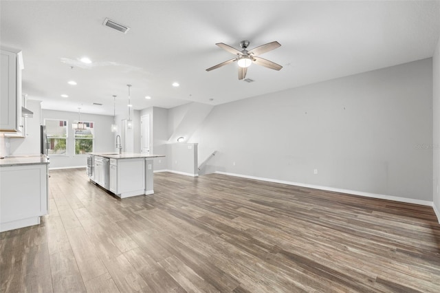 unfurnished living room featuring ceiling fan, wood-type flooring, and sink