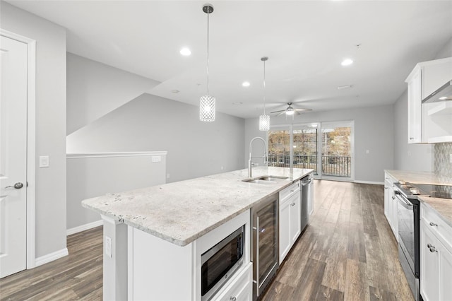 kitchen featuring appliances with stainless steel finishes, white cabinetry, a kitchen island with sink, and sink