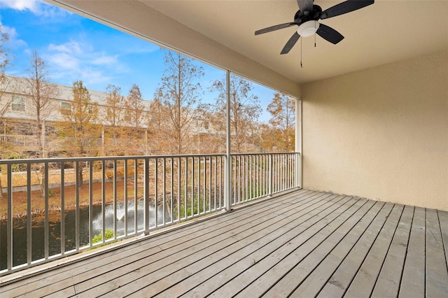 deck featuring ceiling fan and a water view