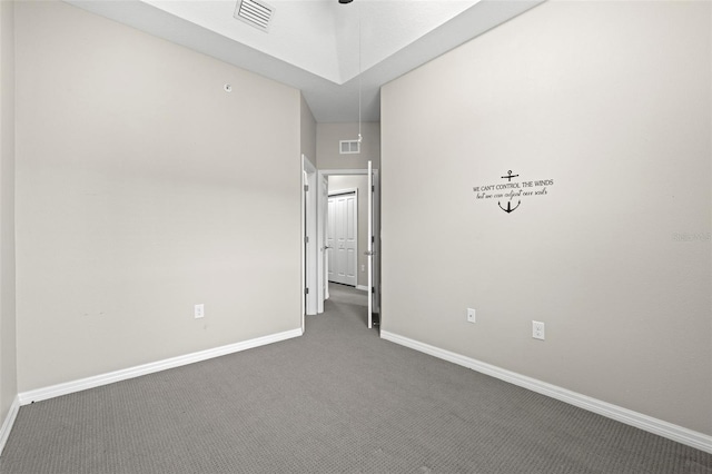 spare room featuring dark colored carpet