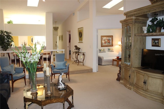 living room with light carpet, a skylight, and high vaulted ceiling