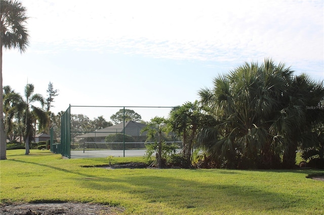 surrounding community featuring a lawn and tennis court