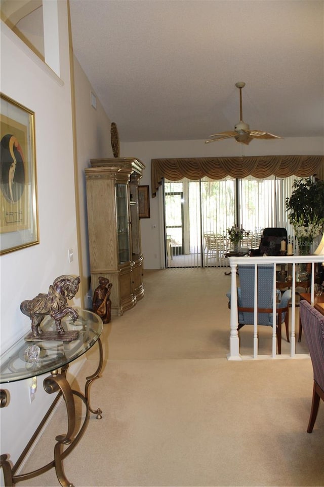 living room featuring ceiling fan, vaulted ceiling, and carpet flooring