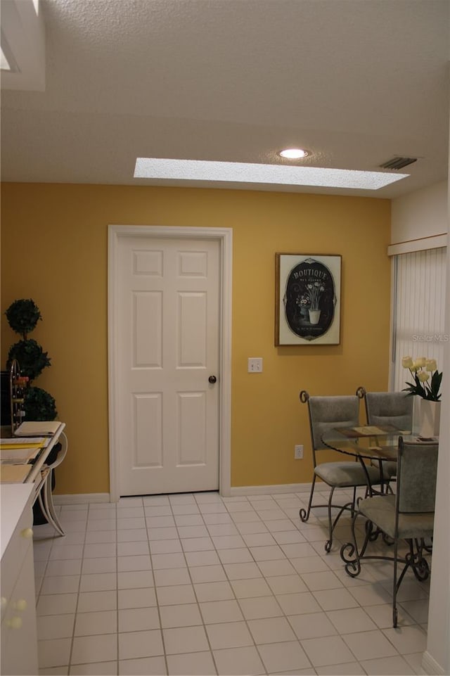 dining area with a textured ceiling, light tile patterned floors, and sink